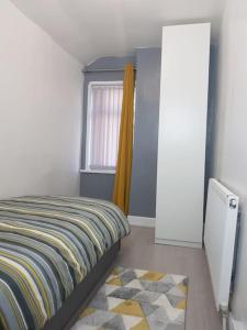 a bedroom with a bed and a window and a rug at Kunda House Parkhill in Birmingham