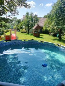 a swimming pool with blue water in a yard at Domek u Czesi 