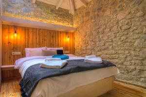 Cozy Villa near Mount Parnassos في أراخوفا: غرفة نوم بسرير كبير في جدار حجري