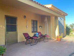 three chairs sitting on the porch of a house at Casa Margherita in Càbras