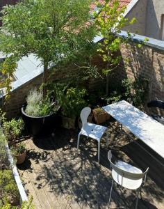 um pátio com uma mesa, cadeiras e árvores em Zehuus mit Domblick und Dachterrasse em Colônia