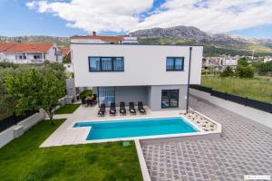 eine Villa mit Swimmingpool und ein Haus in der Unterkunft Kastel One in Kaštela