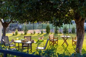 een groep tafels en stoelen in een tuin bij Sunny Studios 1 in Mángana