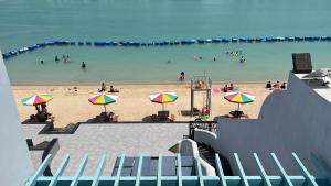 een strand met een stel mensen in het water bij غرفة صالة بلكونة على الشاطئ - عوائل in Durat Alarous