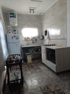 a kitchen with a white refrigerator and a sink at Flor de Lis in Puerto Iguazú
