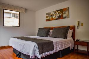a bedroom with a large bed in a room at Cora 96 Street Apartments in Bogotá