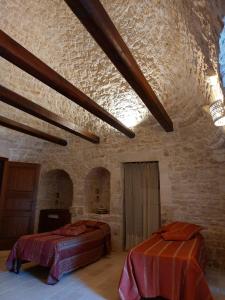 sypialnia z 2 łóżkami w kamiennej ścianie w obiekcie Resort Masseria Cecato w mieście Noci