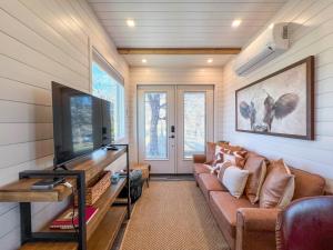 a living room with a couch and a flat screen tv at NEW The Flagship 2 Story Container Home in Waco