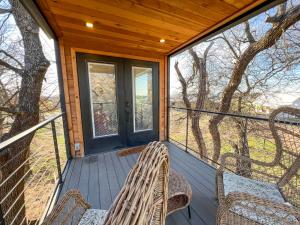 a screened in porch with wicker chairs and windows at NEW The Flagship 2 Story Container Home in Waco