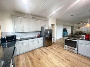 a large kitchen with white cabinets and stainless steel appliances at The Penthouse in Downtown in Fayetteville