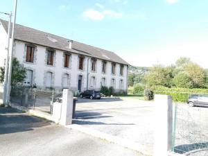a white building with cars parked in a parking lot at L'AUTHENTIQUE *STUDIO *PARKING PRIVE* *WIFI*CALME in Lourdes