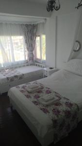 a bedroom with two beds with towels on them at Aişem By Hire in Alaçatı