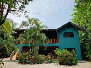 a blue house with a balcony and some plants at Villa Tortuga in Nosara