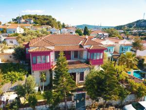 una casa grande con techo rojo en una ciudad en Aişem By Hire en Alacati