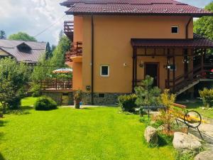 a house with a green yard in front of it at CASA de VIS in Sinaia