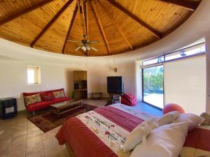 a bedroom with a large bed and a living room at Parcela Olmué La Luz in Olmué