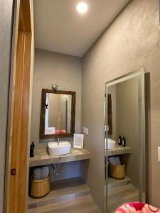 La salle de bains est pourvue de 2 lavabos et d'un miroir. dans l'établissement Hotel Casa Caro, à Bernal