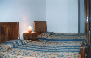 ein Schlafzimmer mit 2 Betten und einem Tisch mit einer Lampe in der Unterkunft Vila Guiomar - Casa da Eira in Alvarenga