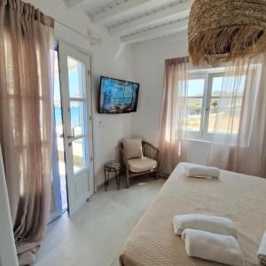 a bedroom with a bed and a tv on the wall at Absolute Water Front properties by Blue Waters Mykonos in Ornos