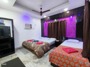 a hotel room with two beds and a flat screen tv at Hotel Bobby house 450m from beach & 1 km from temple in Puri