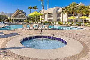 - une piscine circulaire avec des chaises et des parasols à côté d'un complexe dans l'établissement Marriott's Sabal Palms, à Orlando
