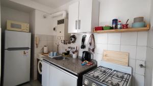 a small kitchen with a stove and a refrigerator at Departamento en excelente ubicación con balcón - Próxima B&B in Cordoba