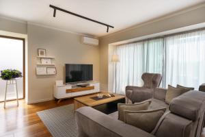 a living room with a couch and a tv at Caprice in Milohnići