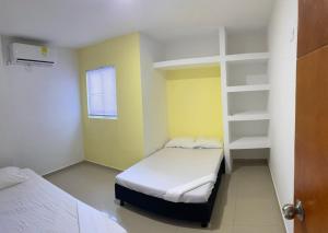 Cette petite chambre comprend 2 lits et une étagère. dans l'établissement Apartamento 202, à Carthagène des Indes