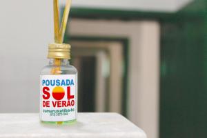 a bottle of soy sauce with some grass in it at POUSADA SOL DE VERÃO - Cumuruxatiba -BA in Prado