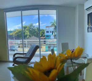 une chambre avec une chaise, une table et une fleur jaune dans l'établissement Apartamento 202, à Carthagène des Indes