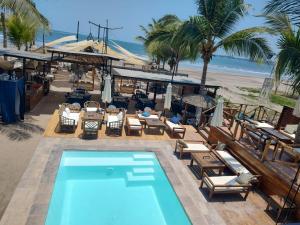 - une piscine à côté d'une plage bordée de palmiers dans l'établissement BAOS, à San Blas