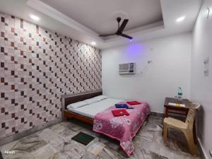 a bedroom with a bed and a table and a chair at Hotel Bobby house in Puri