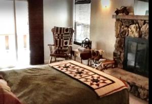 - un salon avec une cheminée et une chaise dans l'établissement Hallelujah Forest, à Big Bear Lake