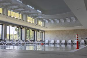 a swimming pool with white chairs in a building at Apartament z Mewami - Dziwnów Bridge Apartaments & Spa in Dziwnów