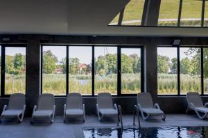 a waiting room with chairs and a pool at Apartament z Mewami - Dziwnów Bridge Apartaments & Spa in Dziwnów