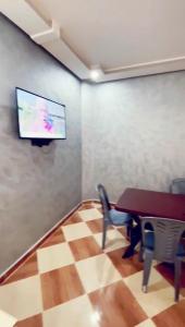 a room with a table and a tv on a wall at حي لمسيرةا شارع الحيط in Tarfaya