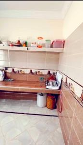 a kitchen with a counter and shelves with dishes at حي لمسيرةا شارع الحيط in Tarfaya
