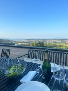 uma mesa com uma garrafa de vinho e uma taça de salada em Villa Trondheim em Trondheim