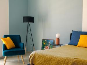 una camera con letto e sedia blu di Fenice a Lizzano