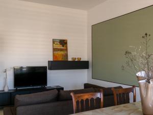 un soggiorno con divano e TV a schermo piatto di Fenice a Lizzano