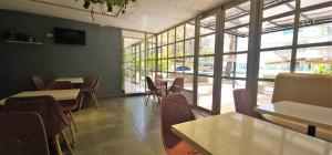 卡塔赫纳Casa Franco Hotel的有桌椅和大窗户的餐厅