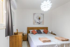 - une chambre blanche avec un lit et un lustre dans l'établissement Brand New Apartment 3Bdr 2 Bth H12, à San Pawl il-Baħar