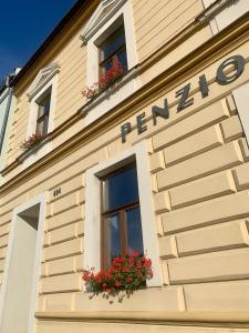 ein Gebäude mit zwei Fenstern und Blumen darauf in der Unterkunft Penzion Ludor in Strážnice