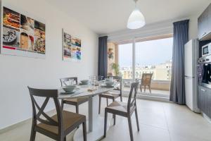 - une cuisine et une salle à manger avec une table et des chaises dans l'établissement Brand New Apartment 3Bdr 2 Bth H12, à San Pawl il-Baħar