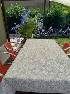 a table and chairs with a table and some flowers at Bertos house tra mare e laguna in Cavallino-Treporti