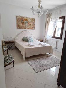 a bedroom with a bed and a chandelier at Bertos house tra mare e laguna in Cavallino-Treporti