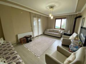 a living room with a couch and a table and a living room at Rize Şehir merkezine yakın doğanın içindesiniz. in Rize