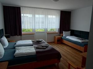 a hotel room with two beds and two windows at Dom Wczasowy Larix in Rewal