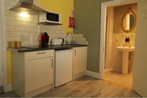 una pequeña cocina con fregadero y microondas en The Snowdonia Apartments, en Llandudno