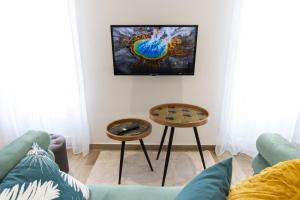 ein Wohnzimmer mit einem Sofa und 2 Tischen in der Unterkunft Élégant Studio Climatisé 'Alma 2' - Cœur de Beziers - Wifi Fibre - Netflix in Béziers